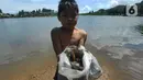 Seorang anak memperlihatkan kerang hasil pencarian di kawasan Situ Rawa Gede, Sirnajaya, Bogor, Jumat (6/1/2023). Mengisi waktu libur sekolah, mereka membantu orang tuanya dengan mengumpulkan kerang yang dijual sebesar Rp 5ribu per kg. (merdeka.com/ Arie Basuki)