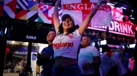 Pendukung Inggris merayakan kemenangan usai peluit akhir dibunyikan  pada pertandingan semifinal EURO 2020 antara Inggris dan Denmark, di Boxpark Croydon di London selatan (8/7/2021). Inggris menang atas Denmark dengan skor 2-1. (AFP/Tolga Akmen)