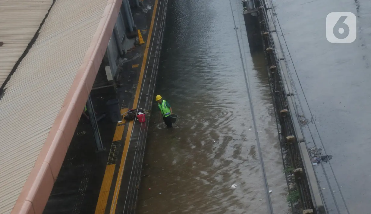 Petugas berusaha mengurangi debit air yang menggenangi rel Stasiun kereta Tanah Abang, Jakarta, Rabu (1/1/2020). Hujan yang mengguyur Jakarta sejak Selasa sore (31/12/2019) mengakibatkan rel terendam dan perjalanan kereta dari dan ke Stasiun Tanah Abang dihentikan. (Liputan6.com/Helmi Fithriansyah)