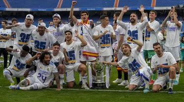 Para pemain Real Madrid berpose dengan trofi gelar La Liga Spanyol usai pertandingan melawan Espanyol di stadion Santiago Bernabeu di Madrid, Sabtu (30/4/2022). Real Madrid menang atas Espanyol 4-0. (AP Photo/Bernat Armangue)