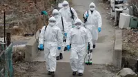 Tentara Korea Selatan yang mengenakan pakaian pelindung berjalan untuk menyemprotkan desinfektan di Seoul, Selasa (3/3/2020). Seoul mengerahkan tentara untuk menyemprotkan disinfektan di jalan dan gang-gang untuk mencegah penyebaran virus corona COVID-19. (AP Photo/Lee Jin-man)