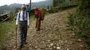 Penduduk tersenyum melihat Durga Kami yang sedang dalam perjalanan menuju sekolahnya di SMA Shree Kala Bhairab di Syangja, Nepal, 5 Juni 2016. Siapa sangka kakek berusia 68 tahun itu ternyata seorang siswa kelas X. (REUTERS/Navesh Chitrakar)