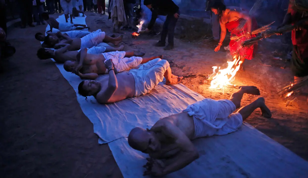 Sejumlah pria Hindu Nepal berguling di tepi sungai Hanumante saat festival Madhav Narayan di Bhaktapur, Nepal (31/1). (AP Photo / Niranjan Shrestha)