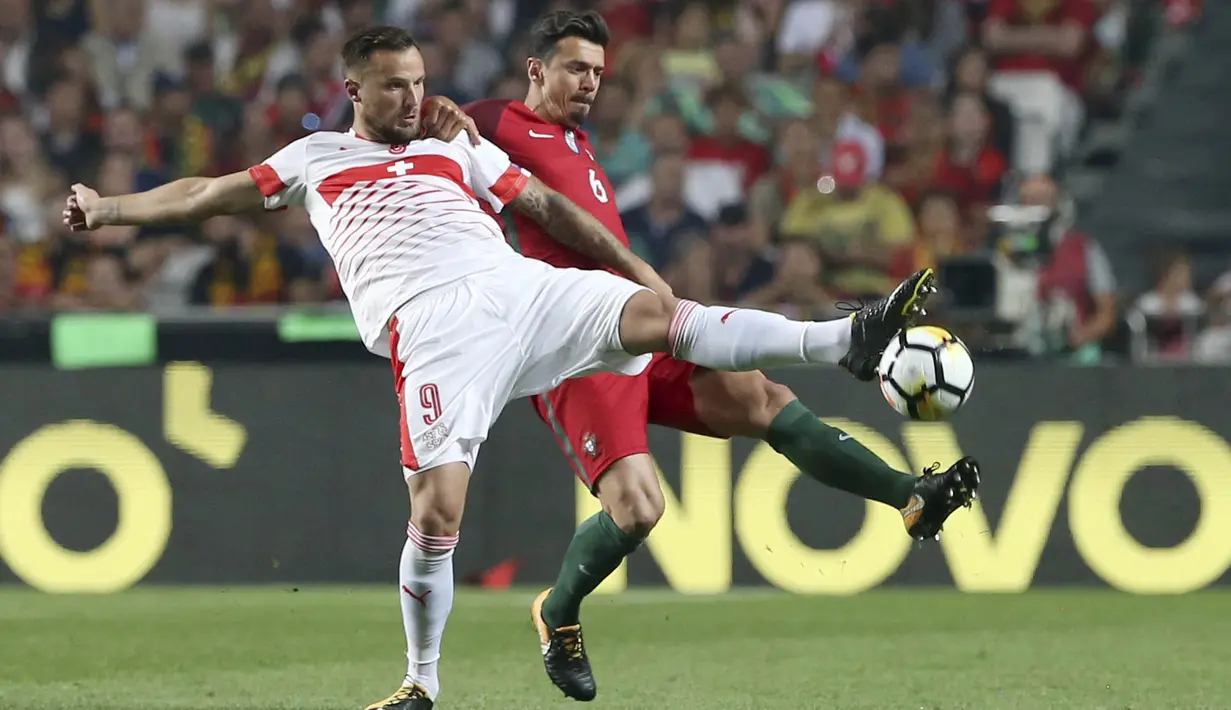 Bek Portugal, Jose Fonte, berebut bola dengan striker Swiss, Haris Seferovic, pada laga kualifikasi Piala Dunia di Stadion Luz, Selasa (10/10/2017). Portugal menang 2-0 atas Swiss. (AP/Armando Franca)