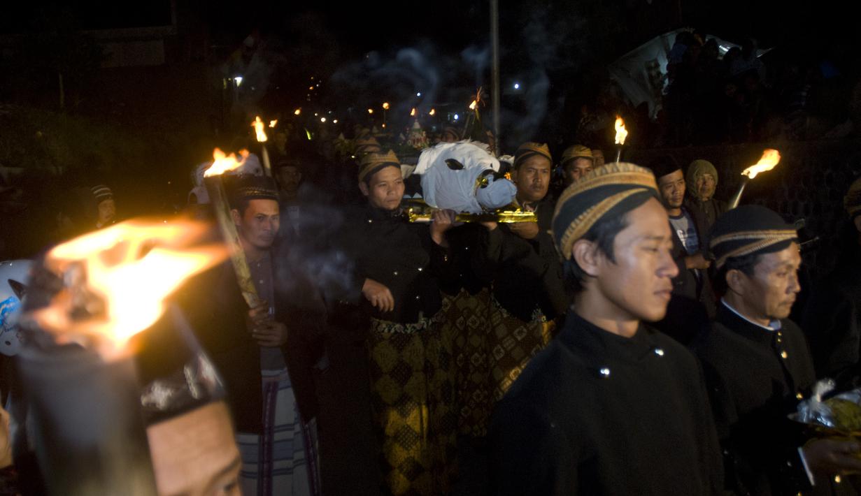 Warga membawa sesaji kepala kerbau dan sejumlah tumpeng pada ritual tahunan 1 Muharam "Sedekah Merapi" di lereng utara Gunung Merapi, Selo, Boyolali, Jateng, Jumat (24/10/2014). (Antara Foto/Andika Betha)