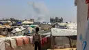 Seorang anak Palestina melihat kepulan asap mengepul dari kejauhan selama pemboman Israel di Rafah, Jalur Gaza Selatan pada 11 Juni 2025. (Foto oleh AFP)
