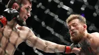 Khabib Nurmagomedov (kiri) meninju Conor McGregor dalam pertarungan UFC 229 di Las Vegas, AS (6/10). Nurmagomedov mengalahkan McGregor dan berhasil keluar sebagai pemenangnya. (AP Photo/John Locher)