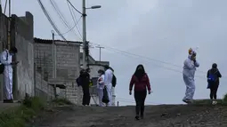 Brigade campuran dari pemerintah kota dan Kementerian Kesehatan mengunjungi lingkungan miskin untuk mendeteksi kasus COVID-19 dan melakukan vaksinasi, di Quito, Ekuador, Rabu (26/1/2022). (AP Photo/Dolores Ochoa)