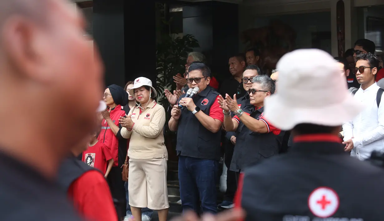 Sekretaris Jenderal Dewan Pimpinan Pusat (DPP) Partai Demokrasi Indonesia Perjuangan (PDIP), Hasto Kristiyanto (tengah) bersama Ribka Tjiptaning selaku Ketua DPP PDIP Bidang Kesehatan saat memberangkatkan relawan dan ambulans ke wilayah terdampak bencana Sumatera di halaman Sekolah Partai PDIP, Lenteng Agung, Jakarta Selatan, Senin (29/12/2025). Dewan Pimpinan Pusat (DPP) Partai Demokrasi Indonesia Perjuangan (PDIP) memberangkatkan 30 unit ambulans beserta 90 tenaga kesehatan (nakes) berikut lebih dari 30 relawan Badan Penanggulangan Bencana (Baguna) ke sejumlah wilayah terdampak bencana di Aceh, Sumatera Utara, dan Sumatera Barat. (merdeka.com/Arie Basuki)
