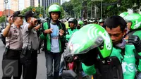 Petugas saat memberikan arahan kepada pengemudi Go-Jek yang diamankan di kawasan Senayan, Jakarta Pusat, Selasa (22/3). Mereka diamankan karena diduga akan melakukan aksi balasan terhadap Sopir Taksi.(Liputan6.com/Fery Pradolo)