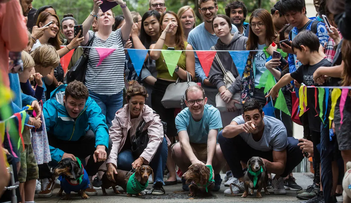 Peserta bersama anjingnya bersiap mengikuti perlombaan di "HK Doggie Dash 2018" di Hong Kong (15/4). Perlombaan ini diadakan untuk mengumpulkan uang bagi anjing yang telah diterlantarkan dan diselamatkan. (AFP Photo/Isaac Lawrence)