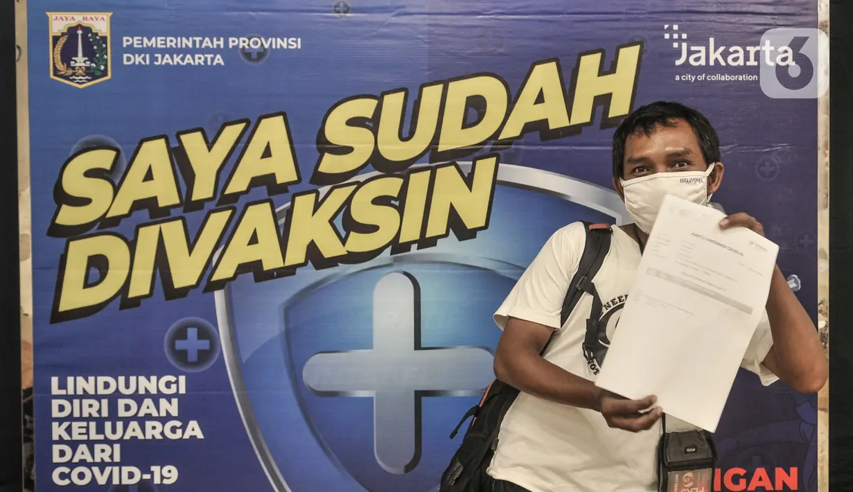 Jurnalis menunjukkan sertifikat usai menerima vaksinasi Covid-19 di Balai Kota, Jakarta, Senin (29/3/2021). Vaksinasi untuk jurnalis ini bertujuan membantu kinerja para awak media dalam beraktivitas di masa pandemi Covid-19. (merdeka.com/Iqbal S. Nugroho)