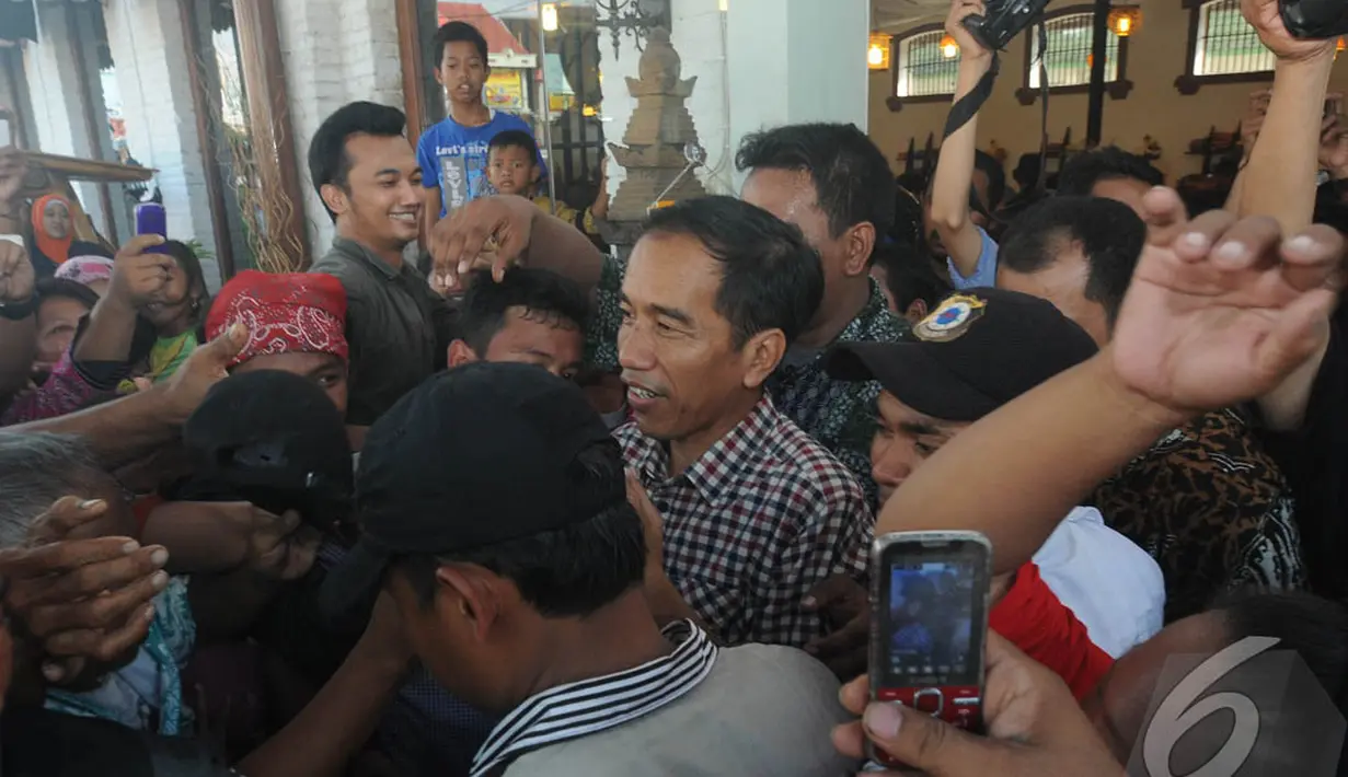 Usai berbelanja batik, Jokowi langsung diserbu warga yang ingin berjabat tangan dengan dirinya, Cirebon, Jawa Barat , Rabu (18/6/2014) (Liputan6.com/Herman Zakharia).
