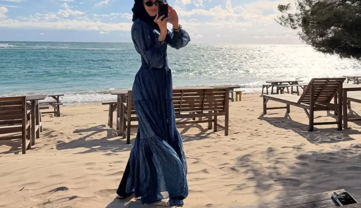 Beby memilih tampil dengan long dress lengan panjang bercorak warna navy. Tampak ia mengenakan kacamata hitam. [@bebytsabina]