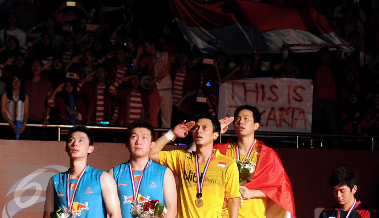 Ganda putra Indonesia, M Ahsan/Hendra Setiawan memberi hormat pada sang Merah Putih usai mengalahkan Liu Xiaolong/QiuZihan (Tiongkok) di final Total BWF World Championships 2015, Jakarta, Minggu (16/8/2015). (Liputan6.com/Helmi Fithriansyah)