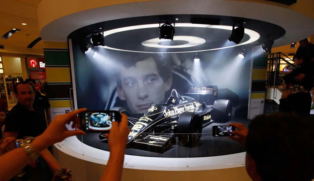Pengunjung mengambil foto dari mobil Ayrton Senna yang penah menjuarai F1 pada tahun 1988, 1990, dan 1991, Sao Paolo, Kamis (10/04/2014) (Reuters/Paulo Whitaker)