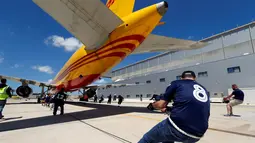 Anggota tim sekuat-tenaga untuk menarik pesawat DHL Boeing 757 sejauh 20 meter di Safi Aviation Park, Malta pada 1 Mei 2019. Kegiatan tarik pesawat tersebut merupakan rangkaian dalam rangka untuk penggalangan dana amal. (REUTERS/Darrin Zammit Lupi)