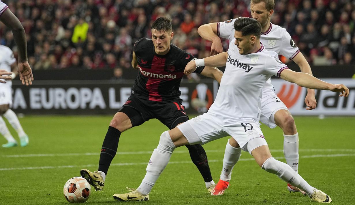 Pemain Bayer Leverkusen, Patrik Schick, berusaha melewati pemain West Ham United pada laga Perempat final Liga Europa di Stadion BayArena, Jumat (12/4/2024). (AP Photo/Martin Meissner)