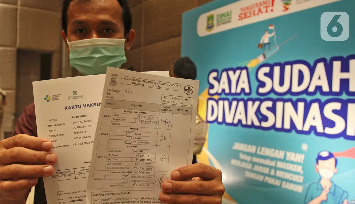 Seorang pria menunjukkan kartu vaksinasi Covid-19 di Ballroom Novotel Tangerang, pada Senin,(1/3/2021). Pelaksanaan vaksinasi Covid-19 tersebut digelar Dinas Kesehatan Kota Tangerang. (merdeka.com/Arie Basuki)