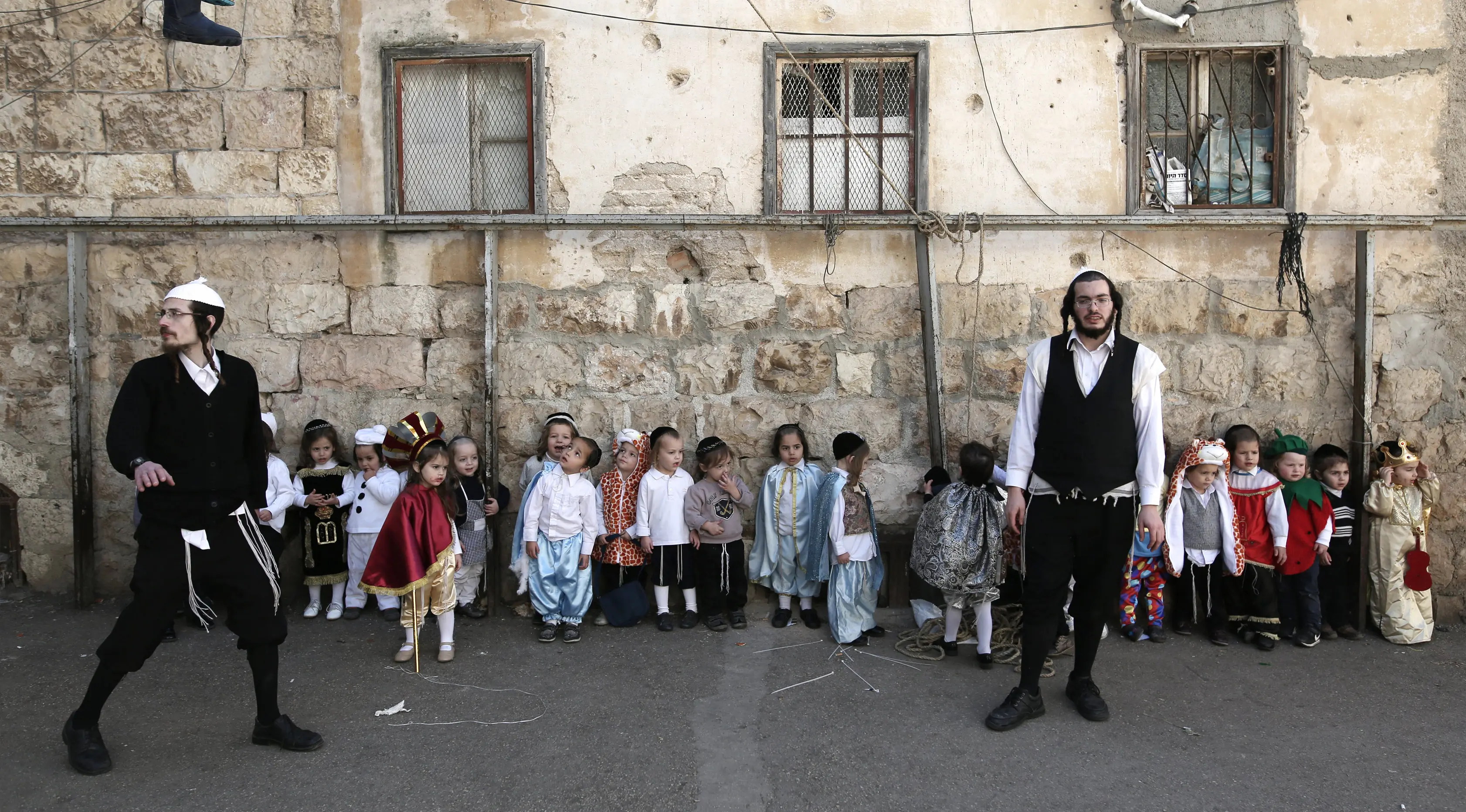 Sejumlah anak-anak Yahudi ultra-Ortodoks mengenakan kostum lengkap dengan atributnya bersiap mengikuti perayaan purim di Yerusalem (8/3). Purim dirayakan tiap tahun menurut kalender Ibrani oleh kaum Yahudi.  (AFP/Menahem Kahana)