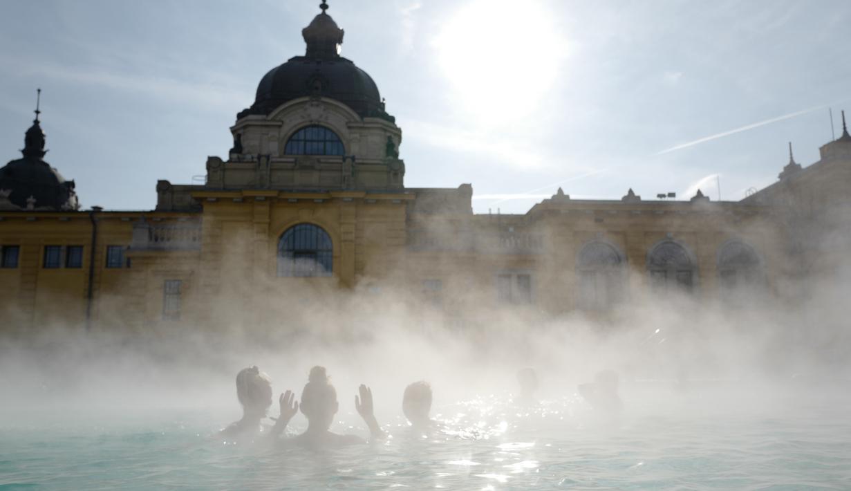Orang-orang menikmati air hangat di kolam relaksasi Szechenyi, di Budapest, Hongaria pada 15 Februari 2019. Szechenyi Thermal Bath adalah salah satu lokasi pemandian umum tertua dan terbesar di Budapest. (VALERY HACHE / AFP)