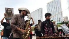 Seniman memainkan alat musik saat mengikuti Karnaval Seni Budaya di Taman Ismail Marzuki, Jakarta, Rabu (10/11/2021). Karnaval tersebut menampilkan pertunjukan seni budaya digelar sebagai rangkaian perayaan HUT ke-53 Taman Ismail Marzuki (TIM). (Liputan6.com/Herman Zakharia)