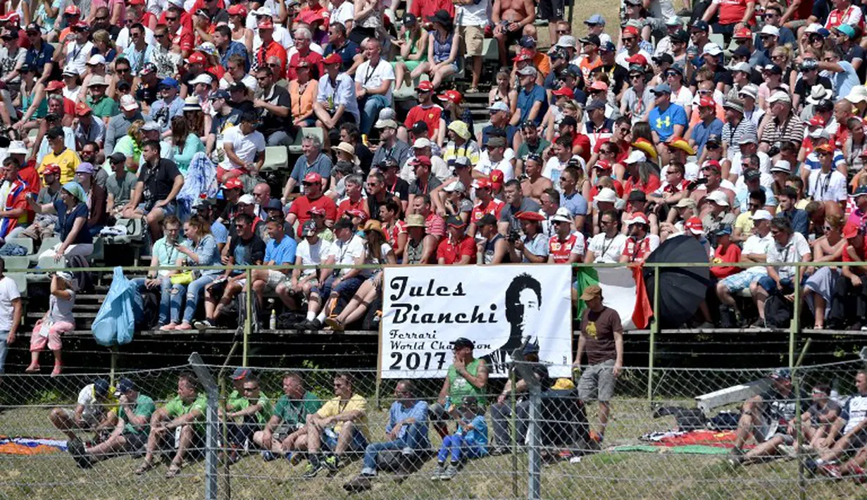 Penonton membawa tulisan sebagai penghormatan kepada Jules Bianchi. (AFP PHOTO/Andrej Isakovic)