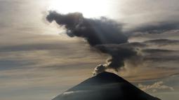 Embusan asap keluar dari kawah Gunung Agung ketika matahari terbit (sunrise) yang terlihat dari Kintamani, Bali, Rabu (13/12). BNPB menegaskan bahwa kondisi Pulau Bali aman bagi wisatawan meski Gunung Agung berstatus siaga. (AP Photo/Firdia Lisnawati)
