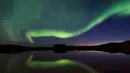 Cahaya aurora borealis menerangi langit malam Desa Erikslund di Vasternorrland County, Swedia (23/8). Fenomena alam yang indah ini terjadi pada bulan Maret-April dan September-Oktober. (AFP PHOTO/ JONATHAN NACKSTRAND)