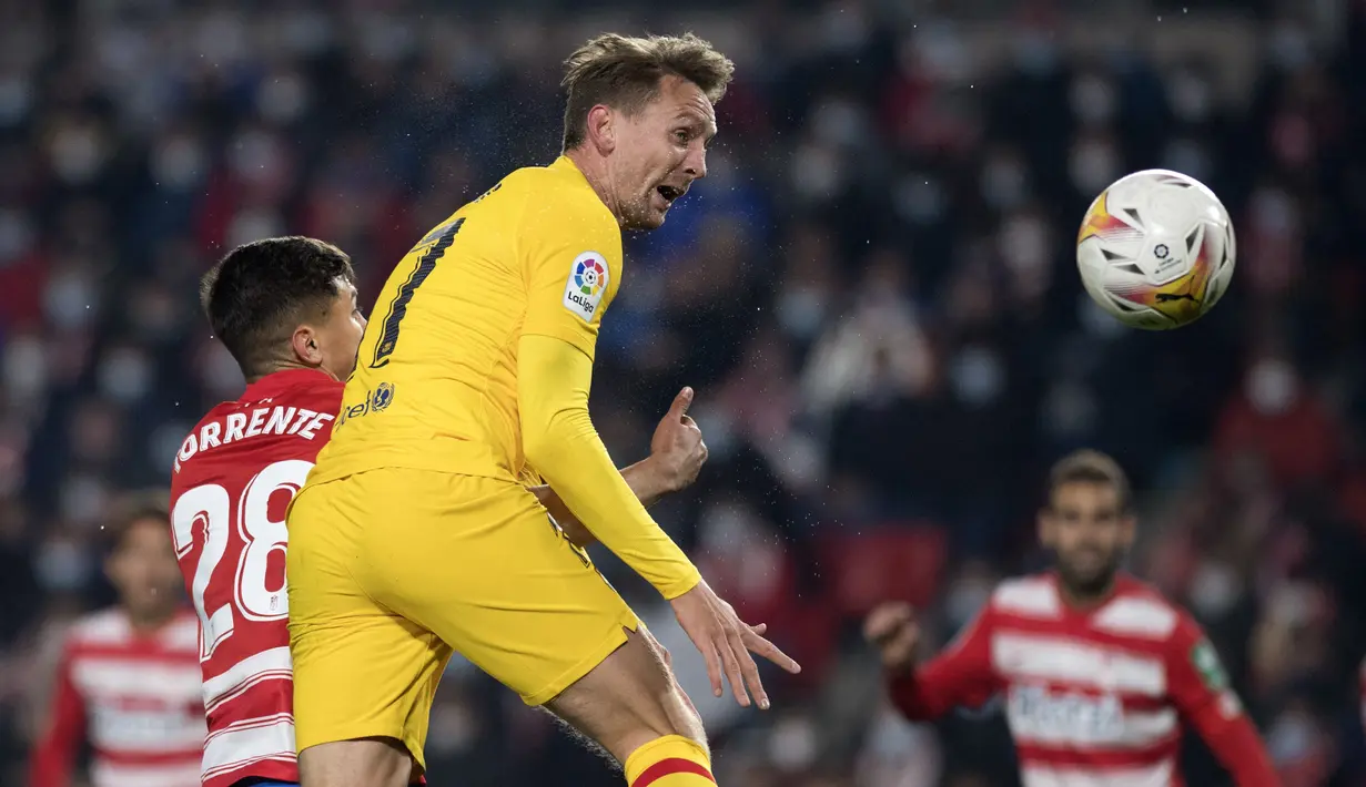 Bek Granada Raul Torente (kiri) bersaing dengan penyerang Barcelona Luuk de Jong dalam jornada ke-20 Liga Spanyol 2021/2022 di Stadion Los Carmenes, Minggu (9/1/2022) dini hari WIB. Barcelona ditahan imbang 1-1 Granada. (JORGE GUERRERO / AFP)