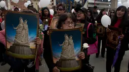 Sejumlah wanita membawa poster yang menyimbolkan gambar Our Lady of Socavon saat mengikuti prosesi untuk menghormati santo pelindung mereka, di Oruro, Bolivia (1/3). Mereka mendadak melakukan prosesi ini. (AP Photo/Juan Karita)