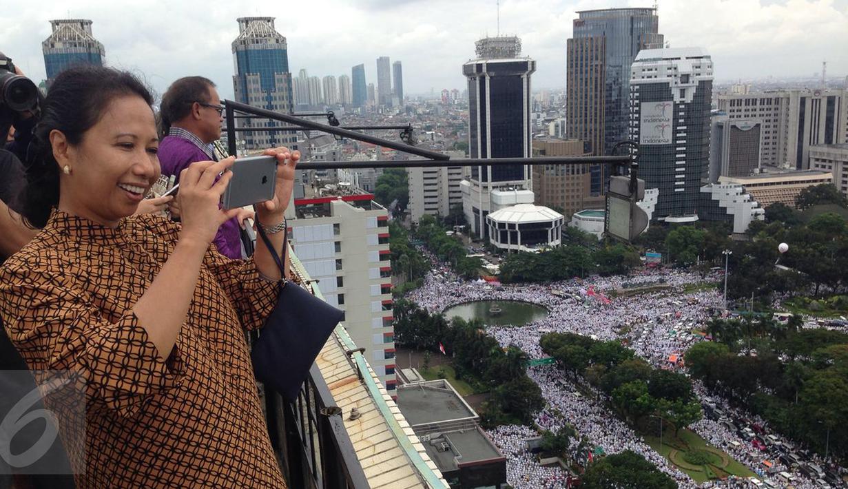Menteri BUMN, Rini Soemarno mengabadikan gambar demo 2 Desember di atas gedung BUMN, Jakarta, Rabu (2/12). Demo 2 Desember digelar sebagai lanjutan dari aksi 4 November 2016. (Liputan6.com/Ferbian Pradolo)