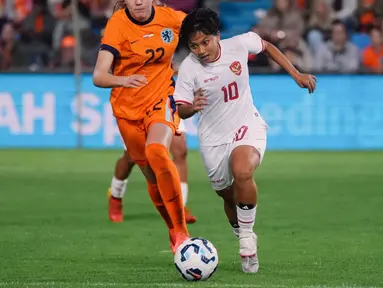 Pemain Timnas Indonesia Putri, Sheva Imut Furyzcha (kanan) menggiring bola melewati pemain Belanda, Lotte Jasmijn Keukelaar pada laga uji coba yang berlangsung di Stadion Devijverberg, Doetinchem, Belanda, Sabtu (26/10/2024) WIB. (Dok. PSSI)