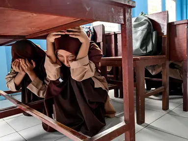 Para siswa sekolah menengah pertama saat mengikuti pelatihan bencana gempa bumi dan tsunami di Lhoknga, provinsi Aceh pada 26 April 2024. (CHAIDEER MAHYUDDIN/AFP)