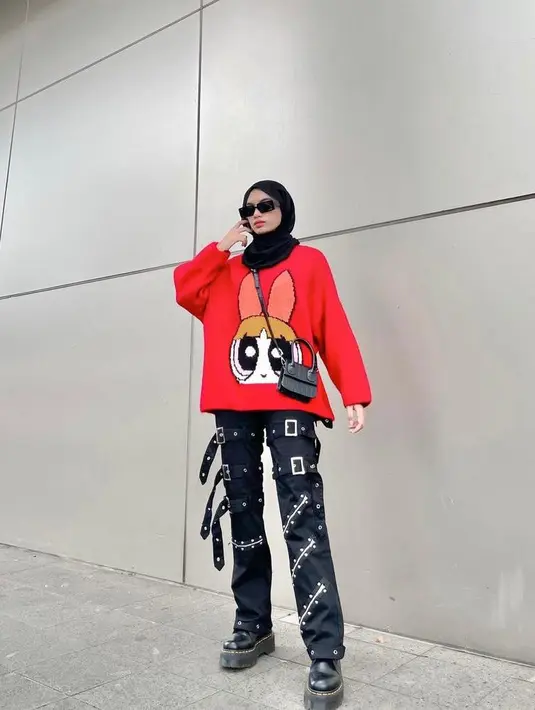 Gaya edgy selebgram Adiva Selsa yang memadukan printed sweater warna merah dengan celana detail belt dan sepatu boots. Kece banget! (Instagram/adiva.selsa).