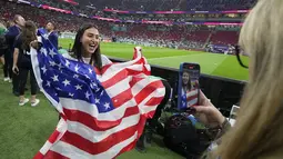 Fans wanita tim Amerika Serikat mengibarkan bendera negaranya sebelum pertandingan grup B Piala Dunia 2022 Qatar antara Inggris dan Amerika Serikat di Stadion Al Bayt di Al Khor, Qatar, Sabtu (26/11/2022). Fans-fans cantik Inggris dan Amerika Serikat mengenakan atribut mendukung negaranya saat laga berlangsung. (AP Photo/Julio Cortez)