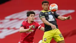 Pemain Southampton, Che Adams berusaha mengontrol bola dari kawalan bek Manchester United, Harry Maguire pada pertandingan lanjutan Liga Inggris di Old Trafford di Manchester, Inggris (13/7/2020). MU bermain imbang 2-2 atas  Southampton. (AP Photo/Dave Thompson,Pool)
