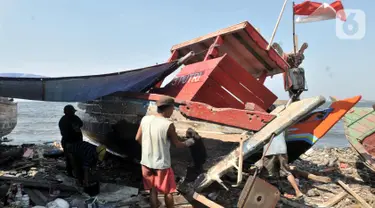 Pekerja menyelesaikan proses perbaikan kapal nelayan di pesisir Marunda, Jakarta, Selasa (22/10/2019). Jasa perbaikan kapal nelayan merupakan salah satu mata pencaharian utama warga pesisir Marunda selain mencari ikan di laut. (merdeka.com/Iqbal Nugroho)