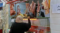 Warga membeli daging untuk persiapan menyambut datangnya bulan Ramadan di Ibu Kota Tripoli, Libya, 1 Mei 2019. Kendati tertekan lantaran dibayang-bayangi oleh pertempuran antara pasukan pemerintah dengan pemberontak, warga Tripoli tetap antusias menyambut Ramadan. (MAHMUD TURKIA/AFP)