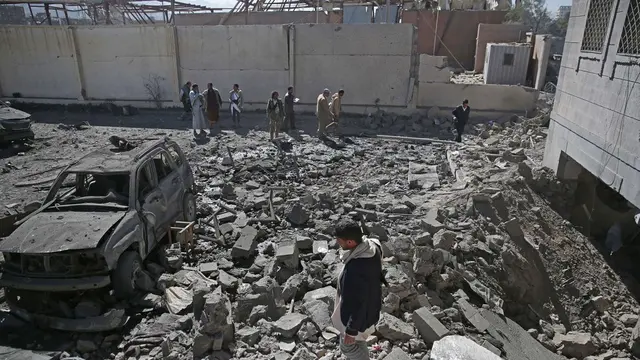 Sejumlah warga mengamati reruntuhan pusat penahanan Houthi yang diserang pasukan koalisi Saudi dari udara di Sanaa (13/12/2017).