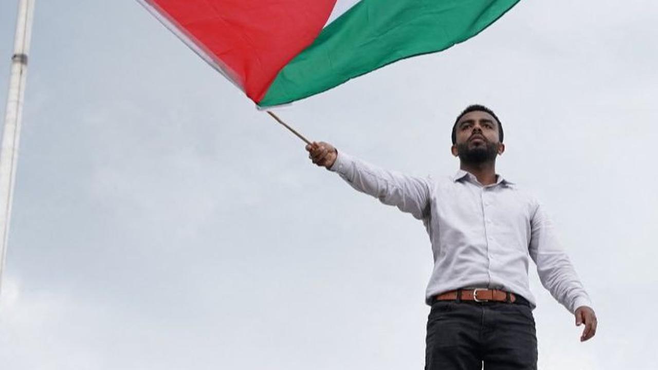 Sementara, pengunjuk rasa tampak mengibarkan bendera Palestina setinggi-tingginya.&nbsp;Foto: Reuters