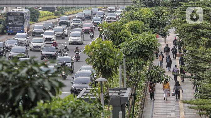 Pegawai pulang kerja berjalan di trotoar Jalan Sudirman, Jakarta, Selasa (12/5/2020). Pemerintah memberi kelonggaran bergerak bagi warga berusia di bawah 45 tahun untuk mengurangi angka pemutusan hubungan kerja (PHK) akibat pandemi virus corona COVID-19. (Liputan6.com/Johan Tallo)
