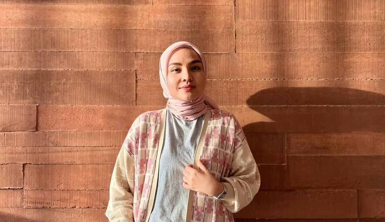 Untuk tampilan casual, t-shirt polos yang dilapisi cardigan dan celana putih seperti Ria Miranda bisa jadi pilihan. [Foto: IG/riamiranda].
