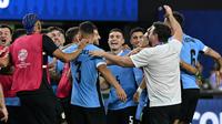 Gelandang Uruguay, Manuel Ugarte (tengah) merayakan dengan rekan setimnya setelah mencetak gol dalam adu penalti untuk memenangkan pertandingan perempat final Copa America 2024 melawan Brasil di Stadion Allegiant, Las Vegas, Nevada pada 6 Juli 2024 atau Minggu 7 Juli 2024 WIB. (Robyn BECK/AFP)