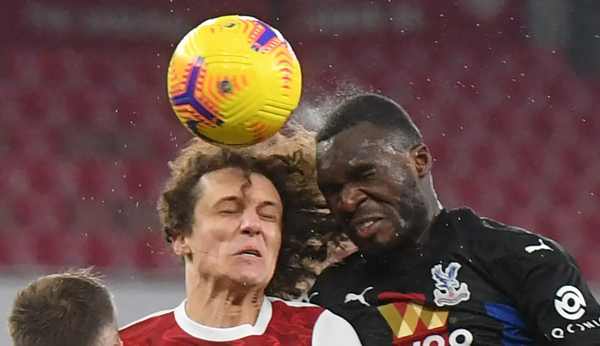 Bek Arsenal, David Luiz (kiri) berduel udara dengan striker Crystal Palace, Christian Benteke dalam laga lanjutan Liga Inggris 2020/21 di Emirates Stadium, Kamis (14/1/2021). Arsenal bermain imbang 0-0 dengan Crystal Palace. (AFP/Neil Hall/Pool)