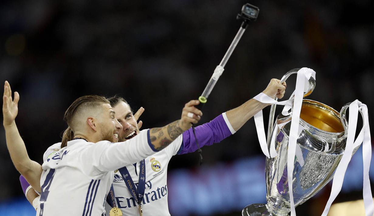 Kapten Real Madrid, Sergio Ramos, selfie bersama Gareth Bale saat merayakan gelar juara Liga Champions di Stadion Millenium, Cardiff, Sabtu (3/6/2017). Madrid menang 4-1 atas Juventus. (AFP/Adrian Dennis)