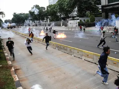 Pengunjuk rasa tolak UU Cipta Kerja bentrok dengan polisi di sekitar Patung Kuda, Jakarta Pusat, Selasa (13/10/2020). Gas air mata ditembakkan ke arah pendemo yang melakukan perlawanan dengan melempar batu dan pecahan kaca. (Liputan6.com/Faizal Fanani)