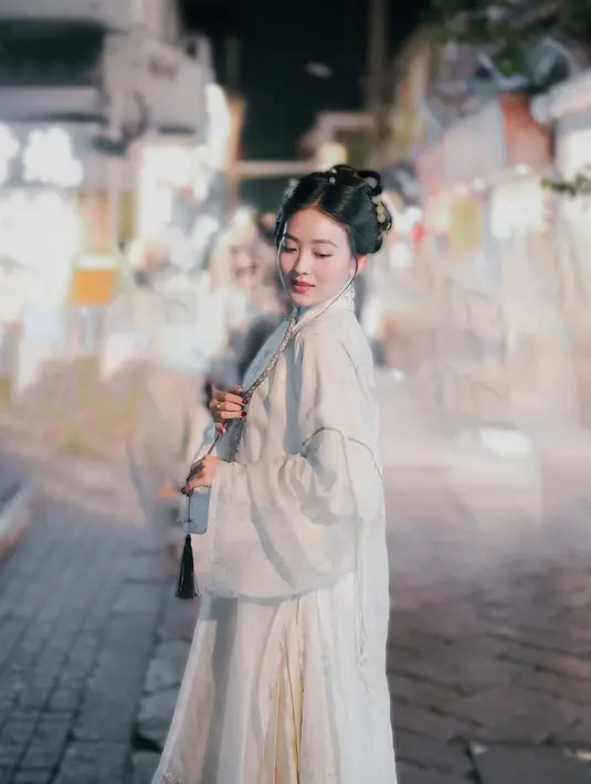 Natasha Wilona mengenakan baju tradisional China model hanfu. Baju tersebut terdiri dari atasan panjang warna putih berbahan halus serta bawahan seperti rok bermotif. Gaya elegan Natasha pun semakin dipertegas dengan gaya rambut sanggulnya khas perempuan China. Lengkap dengan aksesori keemasan yang menghiasi rambutnya. [@natashawilona12]