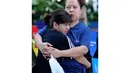 Seorang anak perempuan terlihat terus memeluk ibunya saat perayaan Hari Ibu yang diadakan di sebuah taman di pinggiran kota Manila, (11/5/2014). (AFP PHOTO/Jay Directo)