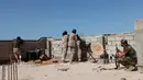Para pasukan militer pemerintah Libya melepaskan tembakan dari lubang beton saat melakukan serangan kepada para pejuang ISIS dari atap atap rumah di daerah Zaafran, di Sirte, Libya, 30 Juni 2016. (REUTERS/Ismail Zitouni)